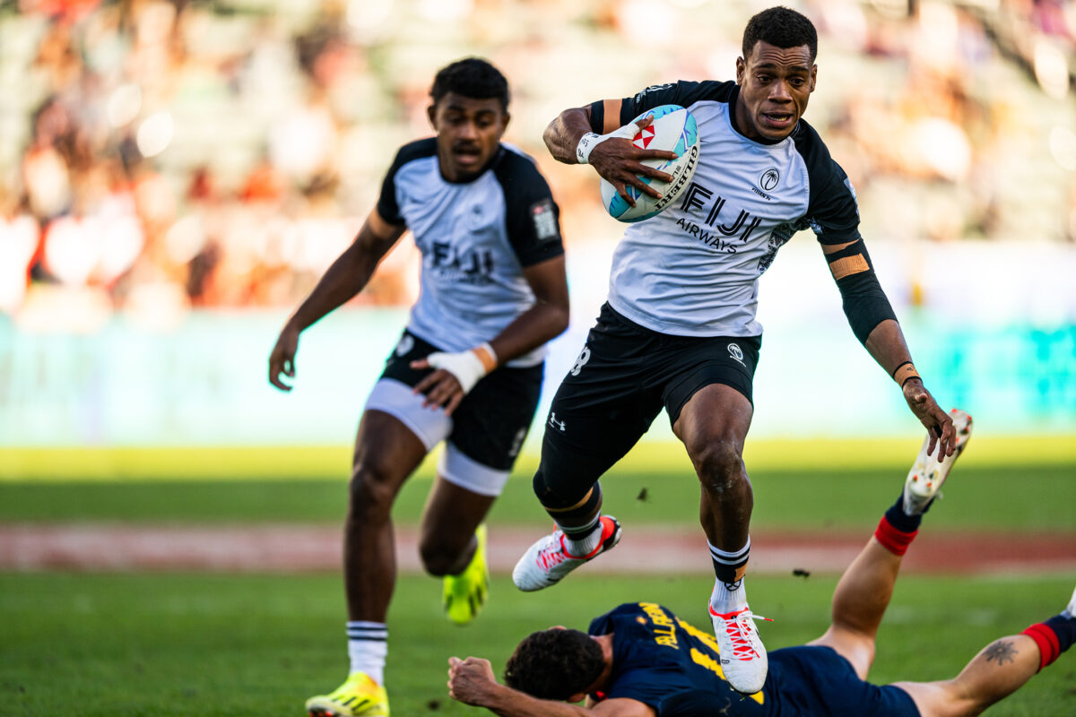 2024 HSBC SVN'S Rugby Tournament in Los Angeles at Dignity Health Sports Park. Fiji Rugby professional rugby player sports action photography. High-impact commercial sports imaging for team branding. Rugby player sprinting with ball, stiff-arming defender. Fast shutter speed sports photography capturing breakaway speed.