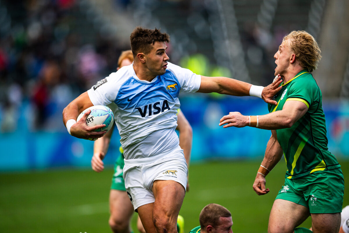 2024 HSBC SVN'S Rugby Tournament in Los Angeles at Dignity Health Sports Park. Argentina Rugby professional rugby player sports action photography. High-impact commercial sports imaging for team branding. Rugby player sprinting with ball, stiff-arming defender. Fast shutter speed sports photography capturing breakaway speed.